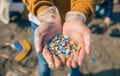 Hands with microplastics on the beach