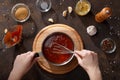 Hands mix the bbq sauce with the whisk in the saucepan. Royalty Free Stock Photo