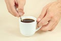 Hands mixing with a spoon of hot coffee in cup Royalty Free Stock Photo