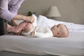 Hands of mom dressing sweet little baby in crawlers Royalty Free Stock Photo