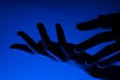 Hands in monochrome blue contrast neon light. Man showing hand palm gesture sign. Artistic photography