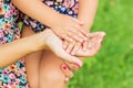 Hands of mother and daughter holding each other. Summer park in background Royalty Free Stock Photo