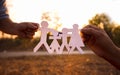 Hands of mother and daughter holding family cut out paper in autumn park on sunset background Royalty Free Stock Photo