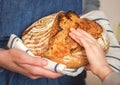 Hands of mother and daughter touching a loaf of freshly baked rustic bread. Concept of family and healthy food