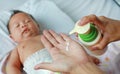 Hands of mother are gives out a white lotion of bottle on her hand to applying baby lotion to her baby Royalty Free Stock Photo