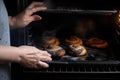 Hands of mother putting burnt croissants out of oven, created with Generative AI technology