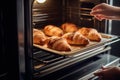 Hands of mother putting burnt croissants out of oven, created with Generative AI technology