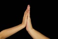 The hands of mother and son joined palms. Isolated women and children arms on a black background.