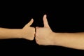 Hands of mother and son show a thumbs up. Isolated women and children palms on a black background. Royalty Free Stock Photo