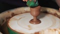 Hands Mould clay product Rotating On Potter`S Wheel And Moisten With Its Sponge craft factory authentic. Close up