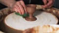 Hands Mould clay product Rotating On Potter`S Wheel And Moisten With Its Sponge craft factory authentic. Close up