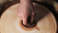 Hands Mould clay product Rotating On Potter`s Wheel And Moisten With Its Sponge craft factory authentic. Close up