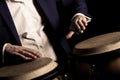 Hands of a musician playing on bongs