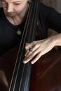 Hands of a musician playing on a contrabass closeup