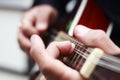 Hands of musician playing mandolin with selective focus on front fingers- hands of musician playing guitar with shallow