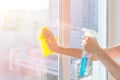 Hands with napkin cleaning window. Washing the glass on the windows with cleaning spray. Royalty Free Stock Photo