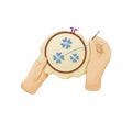 Hands with needle and thread embroidering flowers on canvas