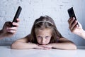 Hands of network addict parents using mobile phone neglecting little sad ignored daughter bored