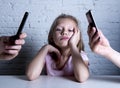 Hands of network addict parents using mobile phone neglecting little sad ignored daughter bored