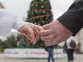 Hands of newly wedded on background of New Year tree