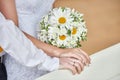 Hands newlywed couple with wedding rings and bridal bouquet