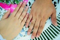 Hands of newlyweds on the background of wedding bouquet. Gold wedding rings on the finger of bride and groom, close-up. Concept Royalty Free Stock Photo