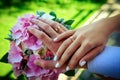 Hands of newlyweds with beautiful gold rings, close-up. Delicate lilac bouquet, stylish manicure. Perfect wedding ceremony concept Royalty Free Stock Photo