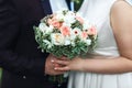 Hands of the newlyweds with a bouquet of the bride close-up. Marriage concept.