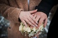 Hands of the newlyweds with wedding rings on the wedding bouquet. Hands of the bride and groom on a bouquet of flowers Royalty Free Stock Photo