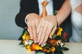 The hands of the newlyweds with wedding rings and the bride`s bouquet on the table Royalty Free Stock Photo