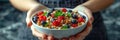 Hands offering a bowl of granola with mixed berries, nuts, and grains. Nutrient-rich superfood and balanced diet concept Royalty Free Stock Photo