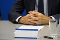 Hands of an official, speaker or boss during a press conference - meeting with the press. Speaker at the talks. Blank plate to