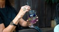 Hands of old European lady sitting in a black dress hold a glass with a cocktail in hand with a gold ring Royalty Free Stock Photo