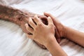 Hands of the old man and a child`s hand on the wood table Royalty Free Stock Photo