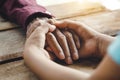 Hands of the old man and a child`s hand on the wood table Royalty Free Stock Photo