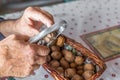 Hands of Old Man Grandpa Pensioner cracks a walnut with a metal nutcracker at a kitchen table, Germany Royalty Free Stock Photo