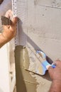 Hands of an old manual worker with wall plastering tools renovating house Royalty Free Stock Photo