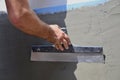 Hands of an old manual worker with wall plastering tools renovating house Royalty Free Stock Photo