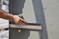 Hands of an old manual worker with wall plastering tools renovating house Royalty Free Stock Photo