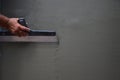 Hands of an old manual worker with wall plastering tools renovating house Royalty Free Stock Photo