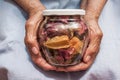 Hands of an old woman holding jar of dried flowers. The concept of longevity. Seniors day. National Grandparents Day. Royalty Free Stock Photo