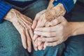 Hands of an old woman and a young man. Caring for the elderly. c Royalty Free Stock Photo