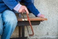 Hands of older man working cutting plank with wood handsaw outside on the ground on picnic Royalty Free Stock Photo