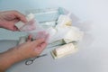 Hands of an older woman taking a sterile gauze bandage out of a first aid kit with medical supplies, health and medicine concept,