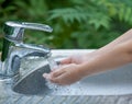 Hands open for drinking tap water. Pouring fresh healthy drink.Child washes his hand under the faucet in the garden. Environment Royalty Free Stock Photo