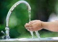 Hands open for drinking tap water. Pouring fresh healthy drink. Good habit. Right choice. Child washes his hand under the faucet Royalty Free Stock Photo