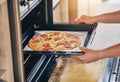 Hands, open oven and cooking pizza for food, restaurant or fast food with skill in home kitchen for baker in Naples Royalty Free Stock Photo