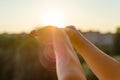 Hands open to the sunset, meditation, the background of the open window in the house, the silhouette of the city and the evening s