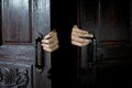 Hands open the wooden door from the inside of the dark Royalty Free Stock Photo