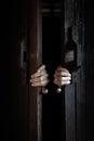 Hands open the wooden door from the inside of the dark room Royalty Free Stock Photo